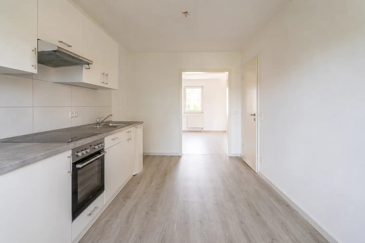Weiße Einbauküche einer leer stehenden, vermietungsbereiten Wohnung in Saarbrücken