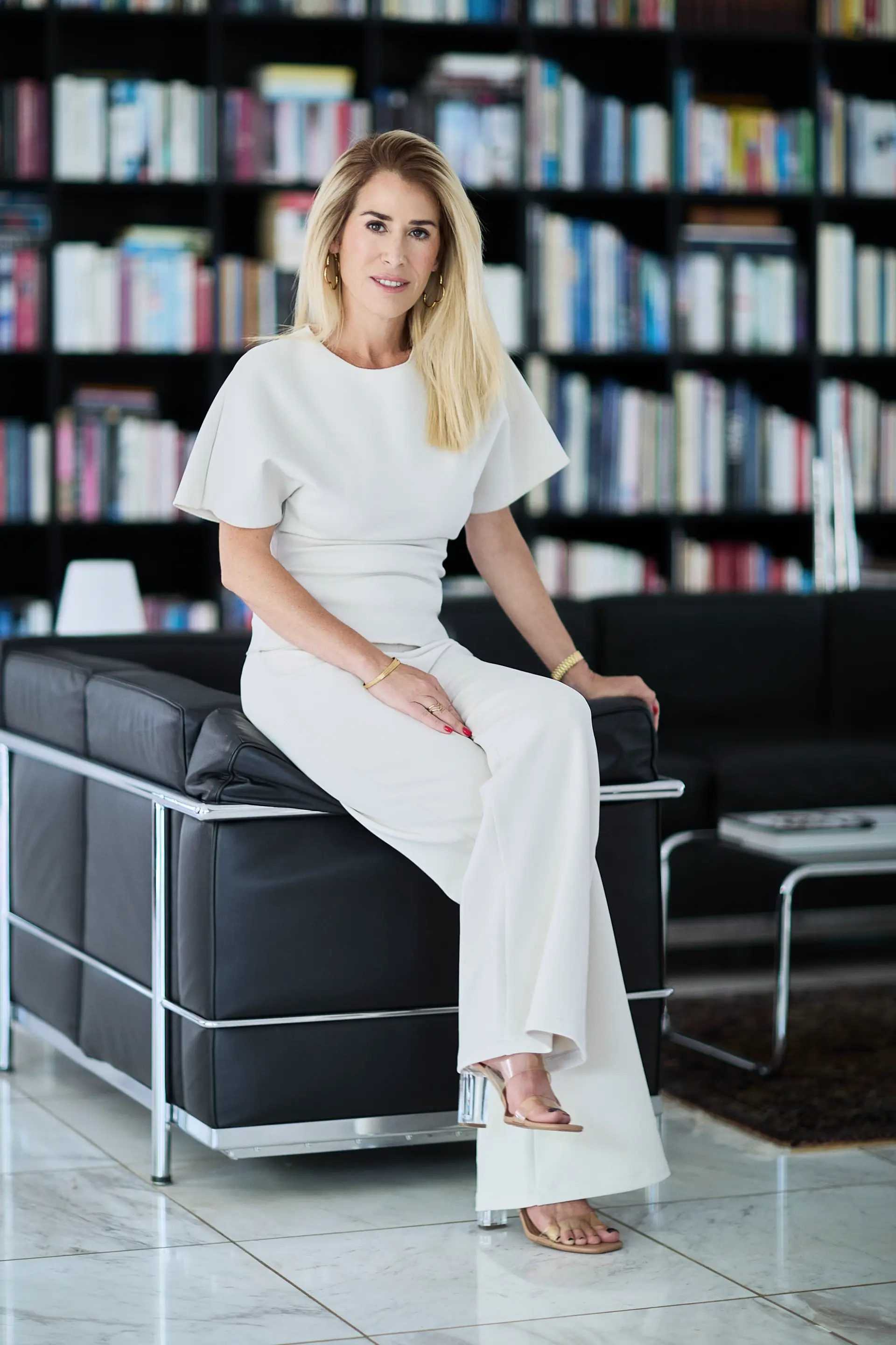 Heja Fuhrmann, Geschäftsführerin von Fuhrmann Immobilien, auf einem Sofa vor einem Bücherregal